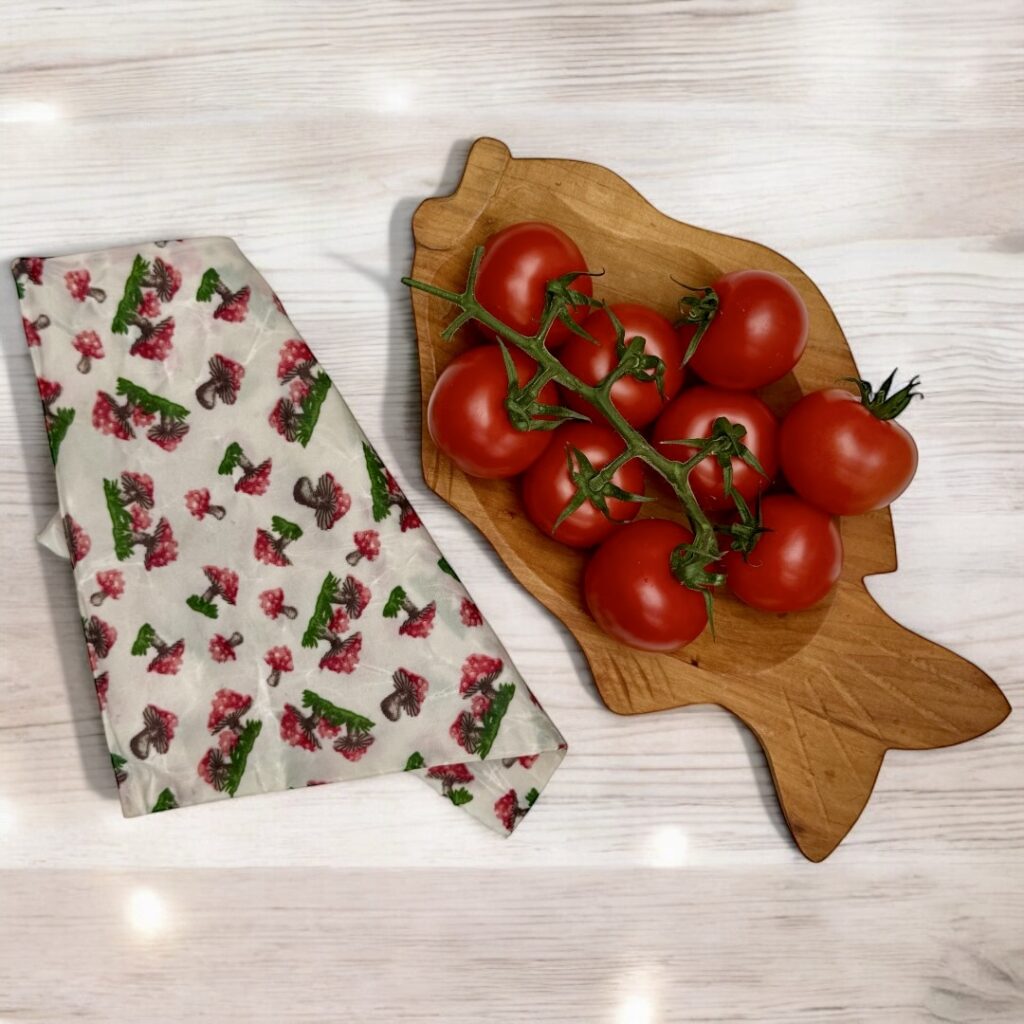 Egy tálkában friss fürtös paradicsom, néhány szem leesett a szárról, mellettük egy méhviaszos tasak.